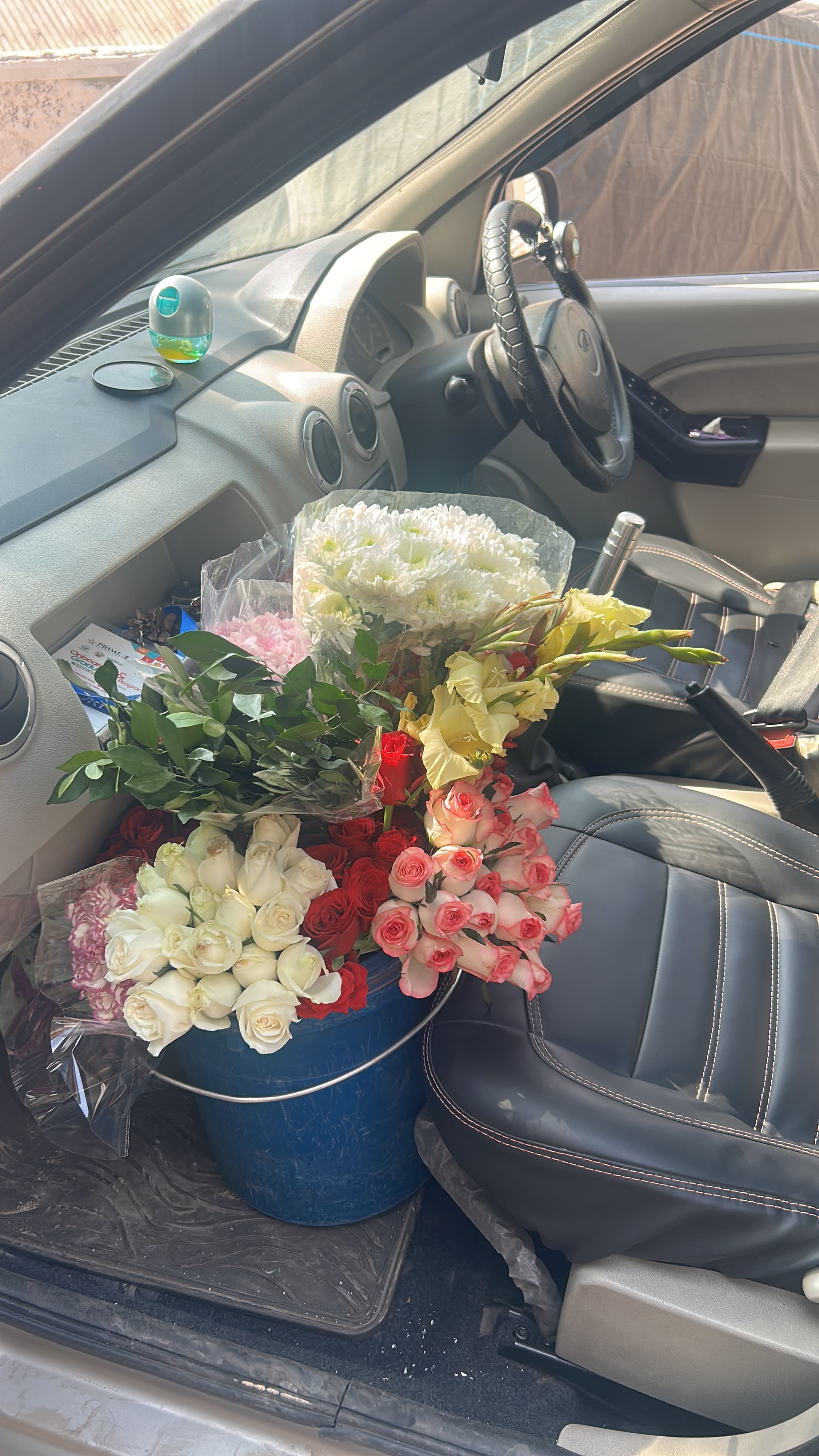 Bouquets loaded onto the seat and floor of a delivery vehicle.